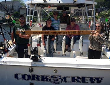 men-women-holding-caught-trout-on-boat